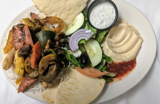 Plate with meat, veggies, hummus and cucumber salad