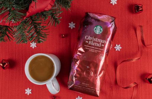 Red Bag of Christmas Blend Coffee next to mug with coffee