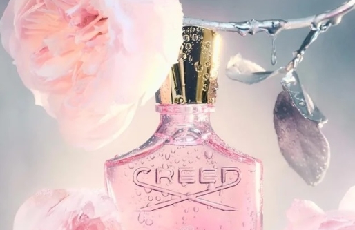 Elongated Bottle of Perfune with Gold Cap handging from Silver-stemmed pink rose