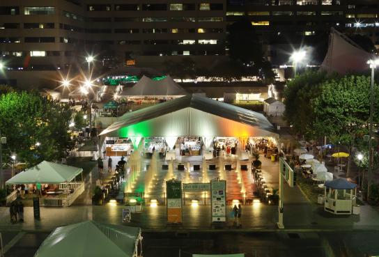 Large tent on Crown Center square at night with Irish Flag colored lighting