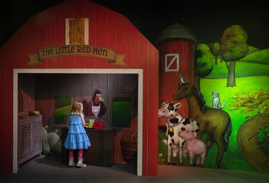 Girl in front of barn with animals