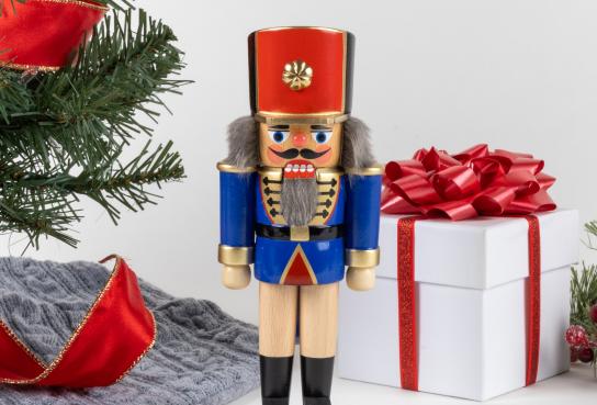 Nutcracker Soldier standing by gift package and tree