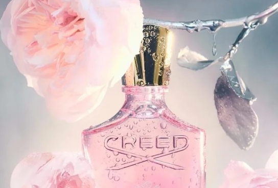 Elongated Bottle of Perfune with Gold Cap handging from Silver-stemmed pink rose