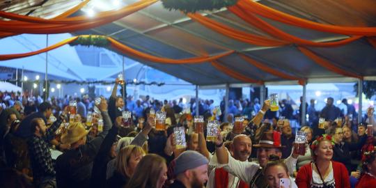 Crowd under Pavilion Singing With Beer Steins