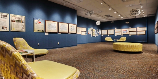 Blue Walls with Snoopy artwork hanging; Yellow chairs and ottoman in foreground
