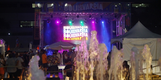 Night shot with fountain yets in front of stage wiht Boulevardia logo and purple, green and blue lights